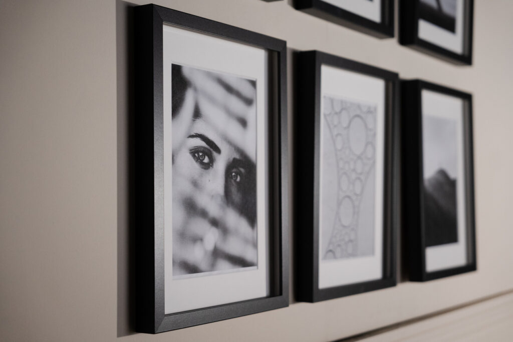 Mur décoré de cadres noir et blanc en symétrie, style galerie photo
