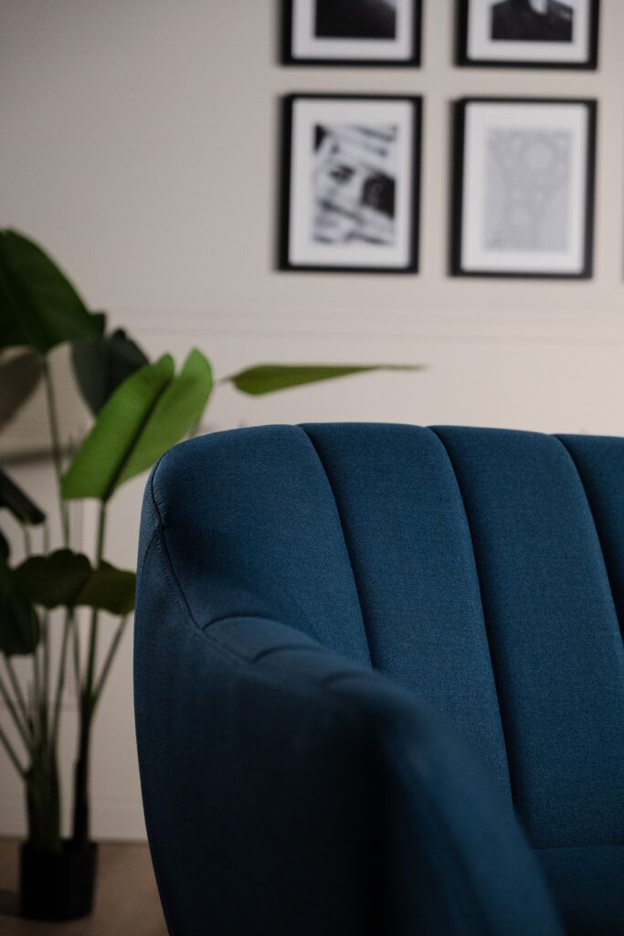 Zoom sur la texture et les courbes du fauteuil en velours bleu