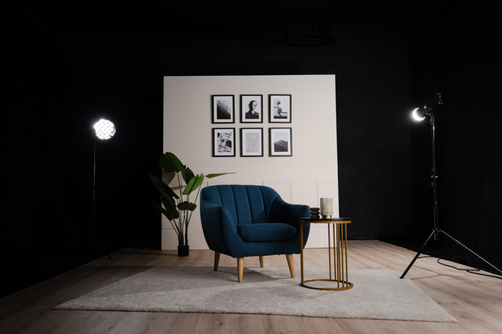 Décor La Parenthèse en plan large, avec fauteuil bleu et mur orné de cadres noir et blanc