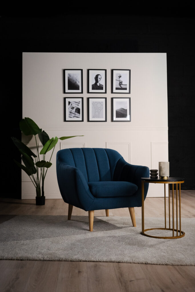 Vue large du décor La Parenthèse avec fauteuil et table sur un tapis gris