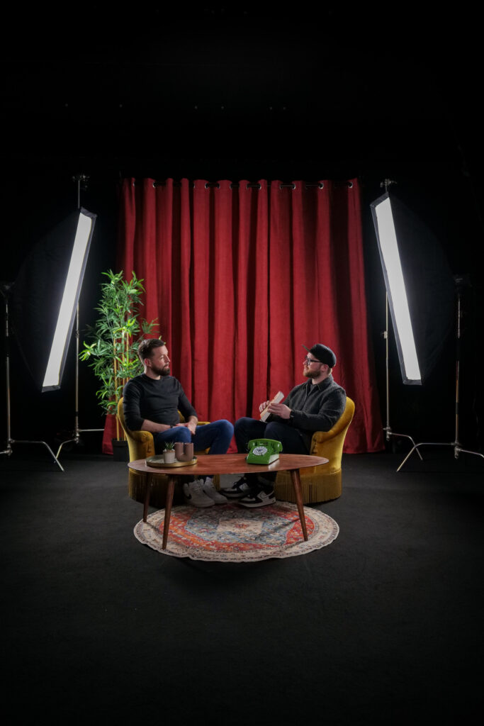 Vue frontale de deux personnes en discussion dans le décor Le Velours
