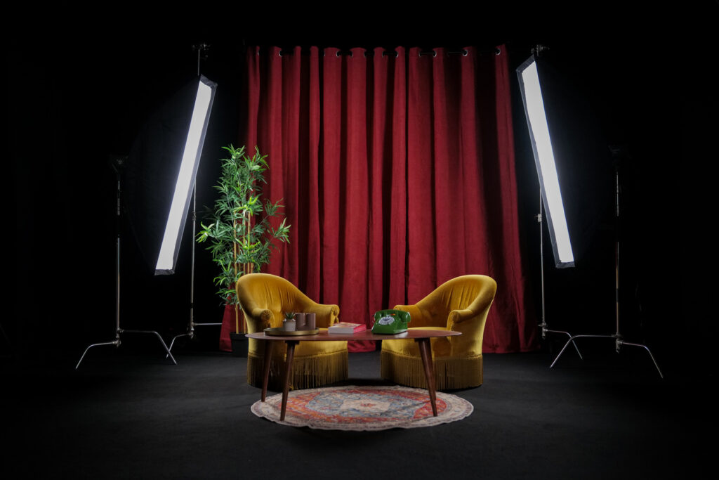Vue grand angle du décor Le Velours avec lumière, rideau, fauteuils, tapis et plante